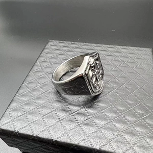 Detailed side view of vintage silver signet ring with shield and embossed cross pattern