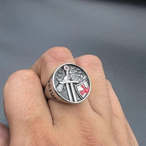 Detailed close-up of vintage Templar cross ring on finger with red enamel and shield