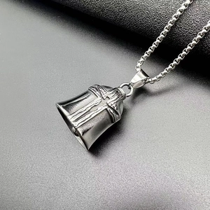 Detailed macro of vintage titanium cross bell pendant with stainless steel box chain