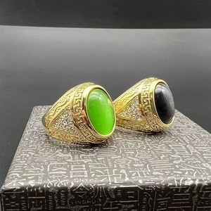 Detailed close-up of gold plated rings featuring Greek key patterns and cat's eye stones