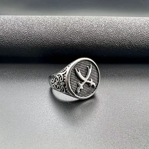 Macro detail of vintage punk ring showing embossed crossed swords and ornate floral side patterns