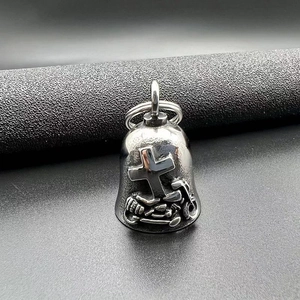 Close-up of silver punk style motorcycle guardian bell with cross and bike relief carving