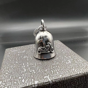 Macro detail of vintage silver guardian bell with cross and cruiser motorcycle relief