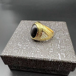 Detailed macro view of gold-plated hip hop ring with black opal and Greek meander pattern
