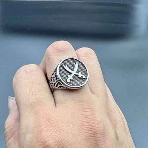 Vintage stainless steel ring featuring embossed crossed swords and engraved scroll patterns
