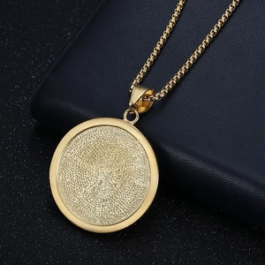 Macro view of gold lion-head pendant showing textured finish and box chain link