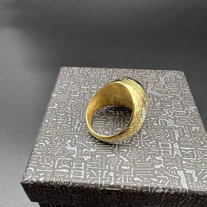 Detailed side view of gold plated hip hop ring featuring Greek key patterns and black stone