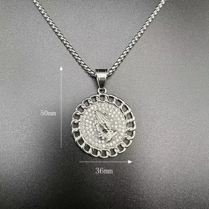 Detail shot of 50mm praying hands pendant with pavé crystals on a thick silver chain