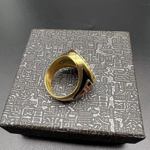 Detailed macro view of vintage gold ring with red cross emblem and black enamel sides