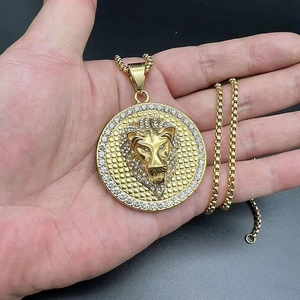 Close-up of gold plated lion head pendant necklace with sparkling zircon borders