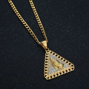 Detailed macro shot of hip-hop triangle pendant with paved rhinestones and praying hands