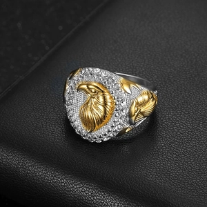 Dettaglio dell'anello con aquila bicolore e strass scintillanti in stile hip-hop