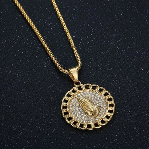 Macro view of hip hop prayer hands pendant with sparkling cubic zirconia inlay