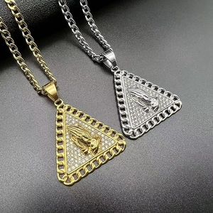 Close-up of hip-hop triangle pendant with praying hands and white zircon stones