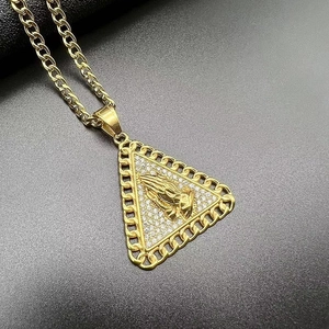 Macro shot of hip hop pendant with praying hands and cubic zirconia pavé detailing
