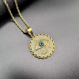 Makroaufnahme des vergoldeten Horusauge-Anhängers mit Strass und blauem Augendetail