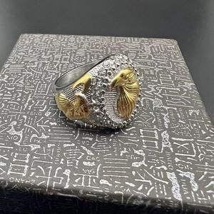 Macro dell'anello hip-hop con teste d'aquila dorate e cristalli bianchi incastonati