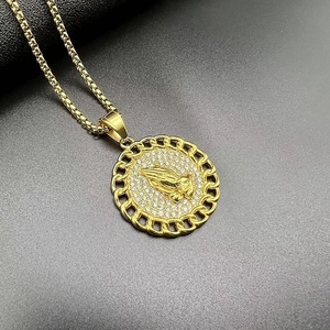 Detail of gold-plated praying hands pendant with pave rhinestones and curb chain edge