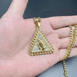 Close-up of hip hop triangle pendant with gold-plated praying hands and cubic zirconia