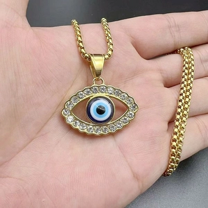 Detail of gold-plated evil eye pendant necklace with sparkling zircons and box chain