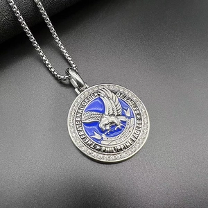 Macro shot of stainless steel eagle pendant with blue enamel and white zircon details