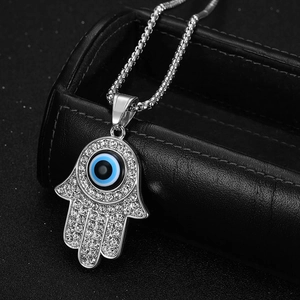 Detail of Hamsa Hand pendant with blue evil eye and sparkling zircons on a box chain