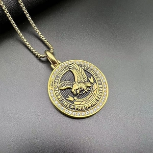 Detailed close-up of golden eagle pendant with crystal rim on black leather surface