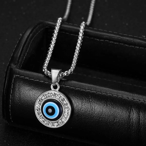 Macro shot of silver Evil Eye pendant with blue enamel and sparkling crystal pavé set