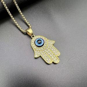 Macro detail of Hamsa Hand pendant with blue Evil Eye and clear crystal pavé setting