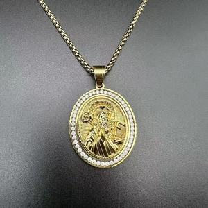 Detailed close-up of gold St. Benedict oval pendant with pavé cubic zirconia and box chain