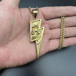 Detailed macro of gold lightning bolt pendant with skull relief on a box chain