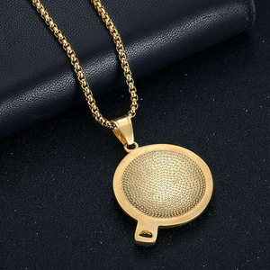 Detail of gold-plated stainless steel hip hop pendant with textured circular design