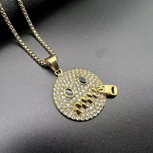Close-up of gold-plated hip hop pendant with rhinestones and zipper mouth emoji