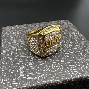 Gros plan sur la bague hip hop plaquée or avec inscription KING et zircons pavés