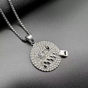 Macro detail of hip-hop zipper face pendant featuring pavé crystals and black stone eyes