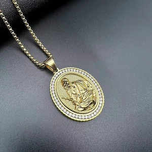 Gold hip hop relief pendant necklace with zirconia accents and box chain on black background