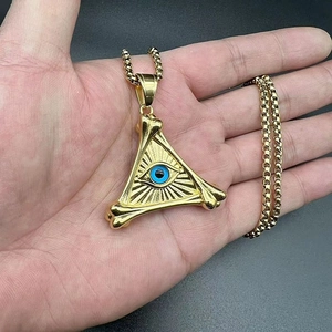 Detailed close-up of gold triangular evil eye pendant with bone-textured frame and blue eye
