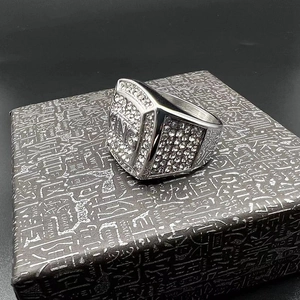 Vue détaillée de la bague hip hop KING argentée avec strass blancs et écrin luxe
