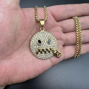 Detail of hip-hop gold-plated pendant featuring cubic zirconia and zipper smile face