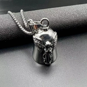 Close-up of titanium steel motorcycle bell pendant with engraved angel wings design