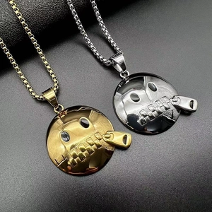 Macro detail of gold and silver polished zipper-face pendants on black leather