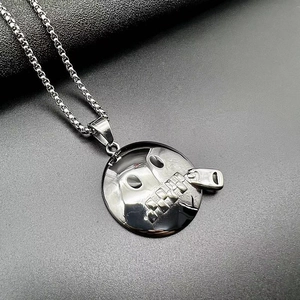 Macro detail of silver stainless steel pendant featuring a skeleton zipper mouth design