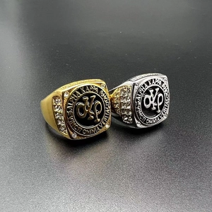 Dettaglio degli anelli sigillo AKP oro e argento con smalto nero e strass