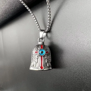 Nahaufnahme von Vintage-Glockenanhänger mit rotem Kreuz und blauem Teufelsaugen-Detail