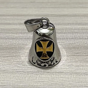 Detailed macro view of vintage stainless steel biker bell pendant with golden cross