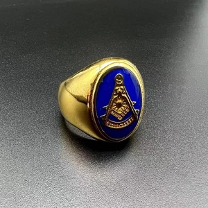 Macro shot of gold-plated Masonic Freemason ring with blue inlay on black background