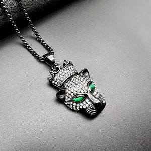 Détail macro du pendentif tête de léopard avec yeux gemmes verts et cristaux