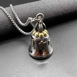 Macro view of stainless steel guardian bell pendant with gold relief mantra carvings