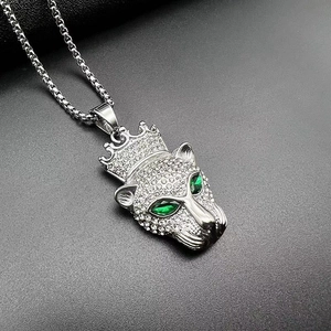 Vue macro du pendentif léopard hip-hop argenté avec couronne et yeux en pierres vertes