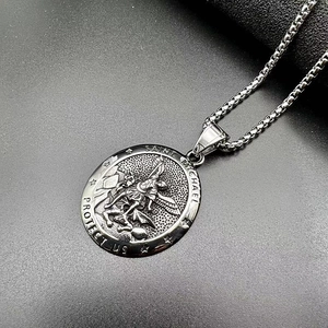 Détail macro du pendentif relief Saint Michel sur une chaîne à mailles carrées robuste